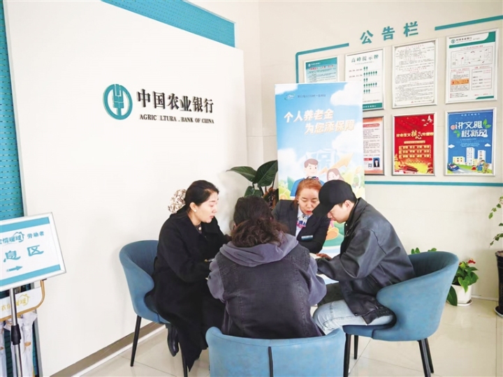 工作人员向群众介绍社？ò炖硎褂檬乱。